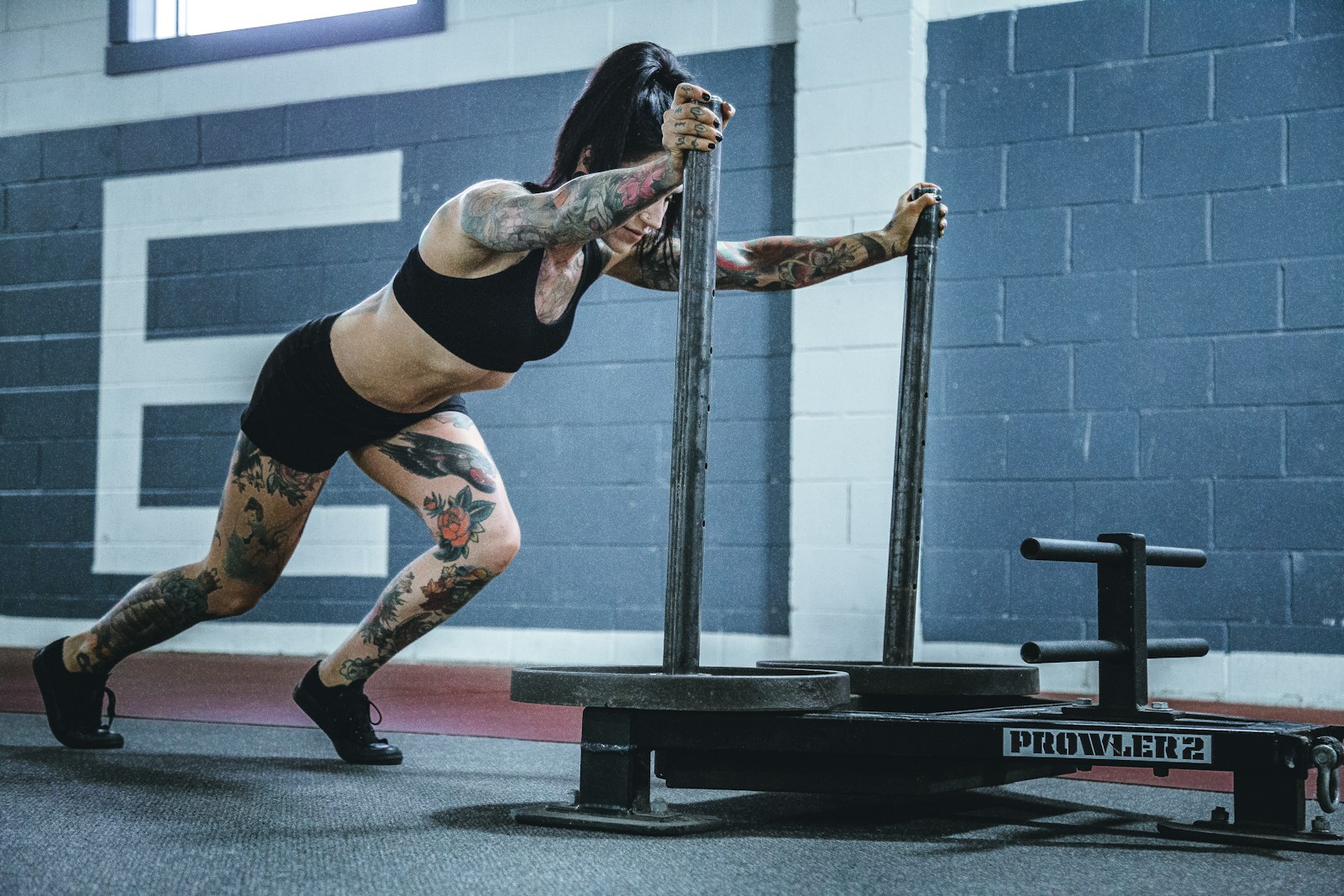 Member pushing a sled across the floor